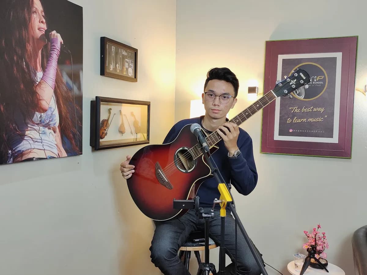 Murid BnP Music School memainkan gitar akustik di ruang kelas