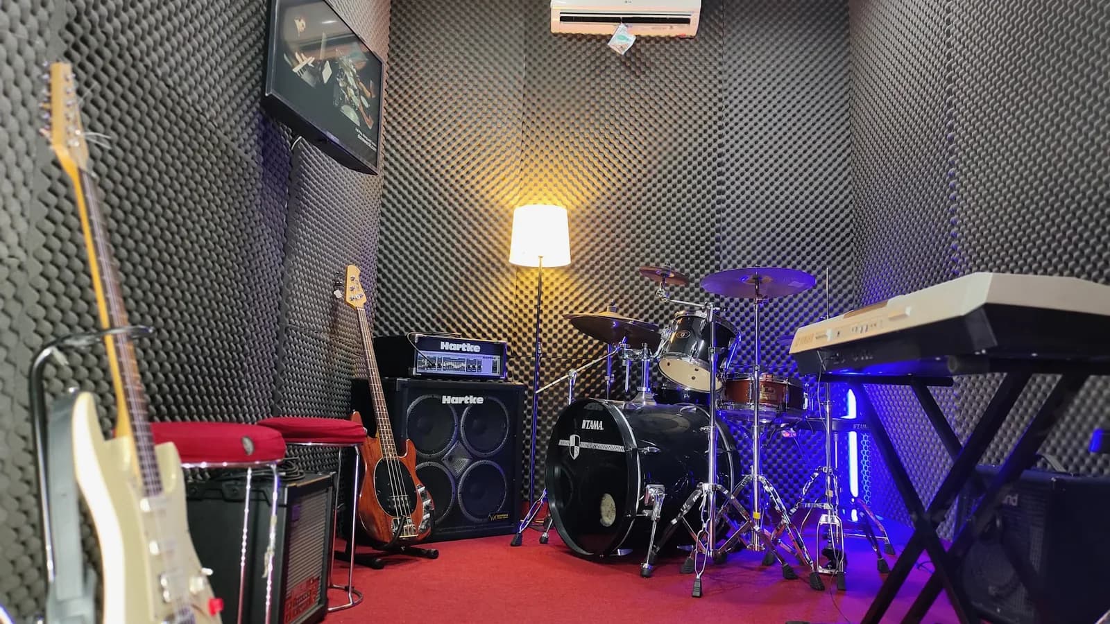 Ruang band BnP Music School dengan drum set, bass, gitar, dan amplifier